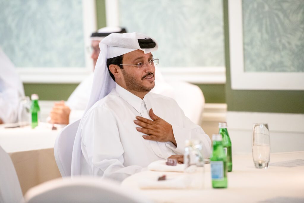 Man sitting at a table with his hand on his chest in a gesture of gratitude.