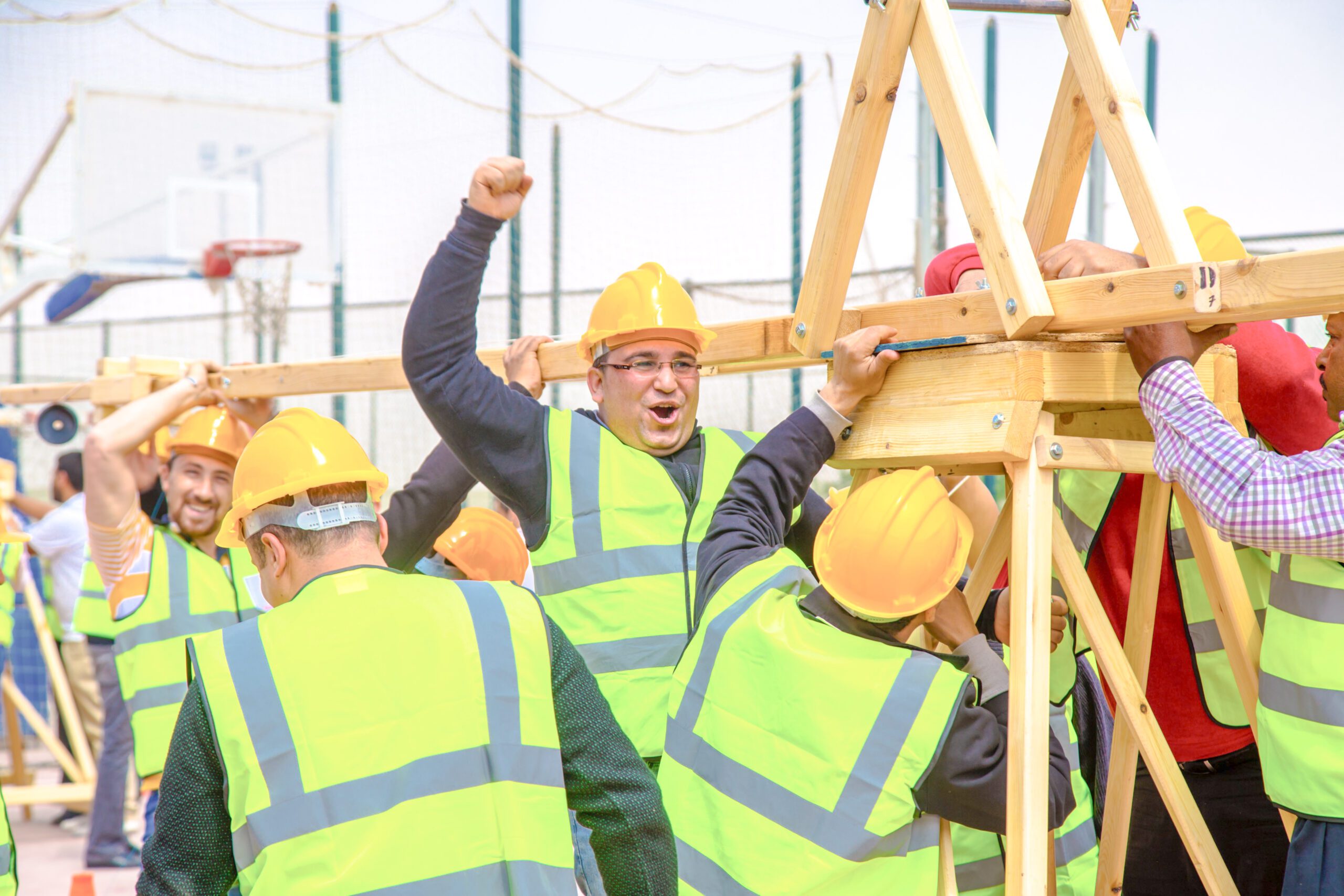 High-energy team-building activity: Men working together to construct a crane