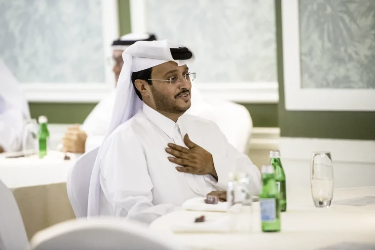 Man sitting at a table with his hand on his chest in a gesture of gratitude.