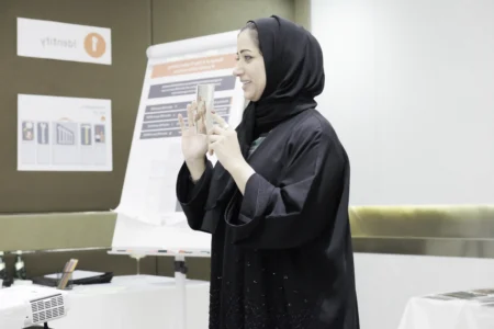 Woman in a classroom setting, sharing an image with her audience