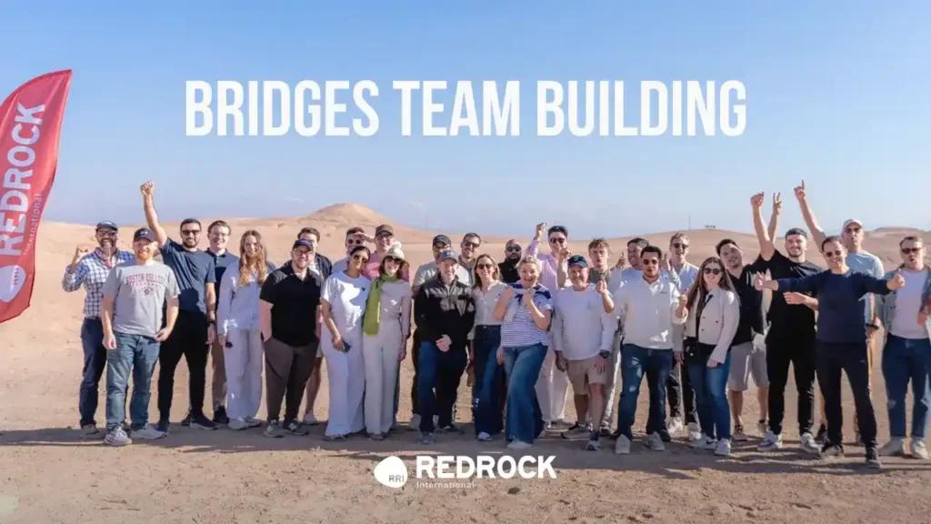 Group of people taking a picture in Agafay Desert after finishing bridges team building with Red Rock International Morocco